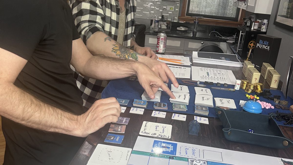 Two playtesters leaning over the board during the Session 3 co-op playtest