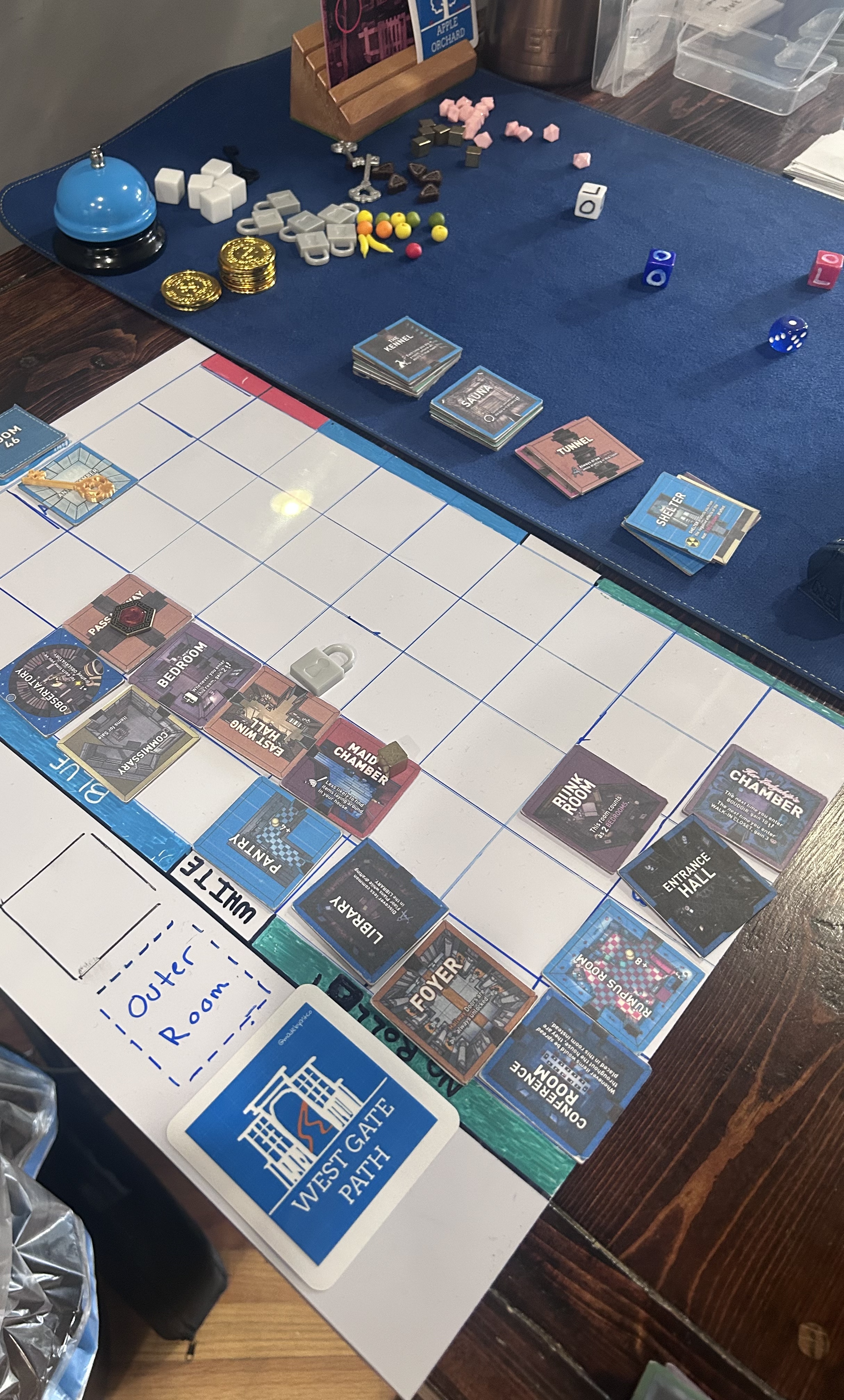 Angled view of the board late in the session — outer room tiles lined up on the mat, rooms placed deep into the grid, Conference Room and Foyer visible in the lower ranks