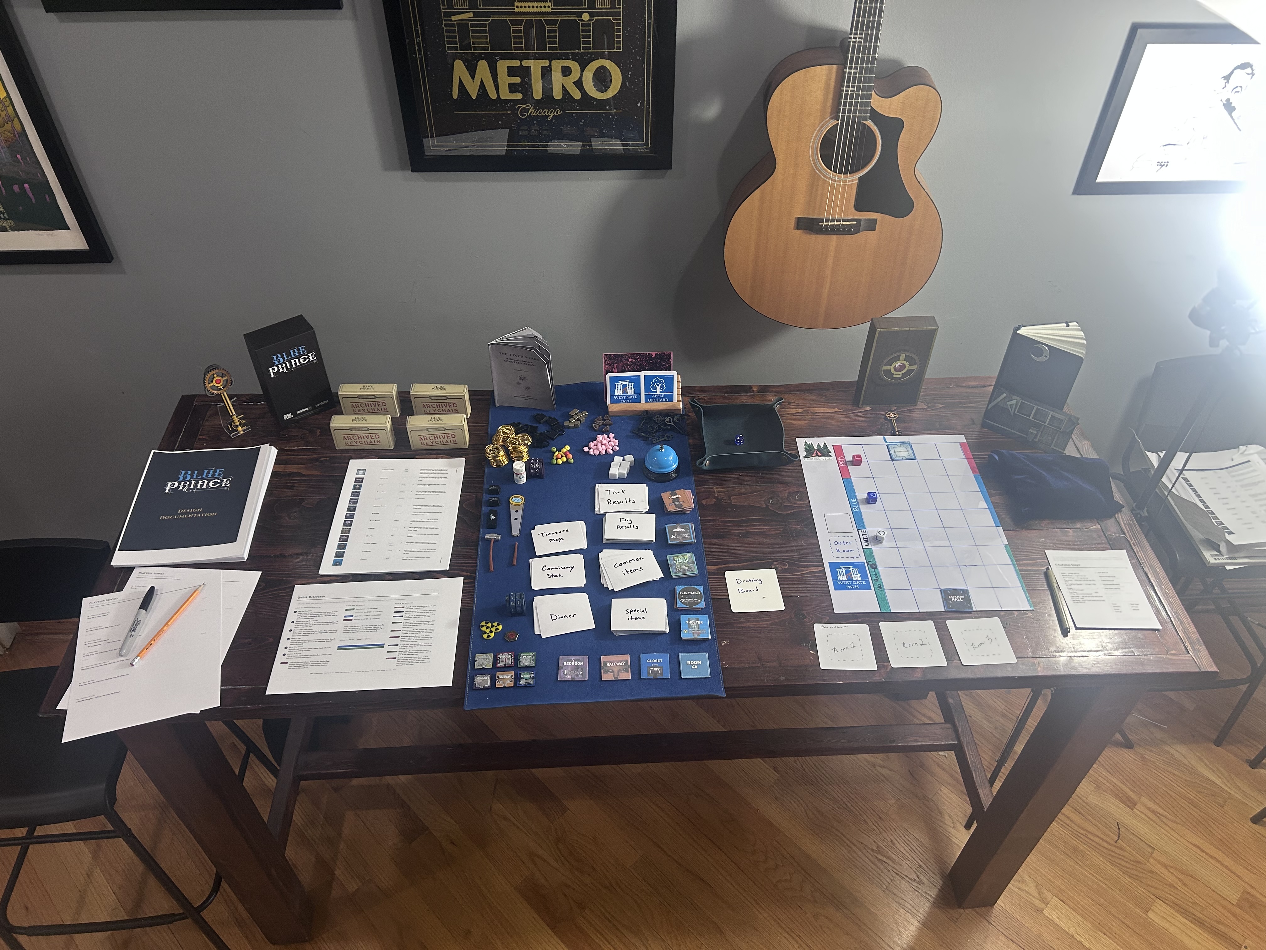 The full playtest setup — Blue Prince board game spread across a dining table with all components, reference cards, and printed documentation