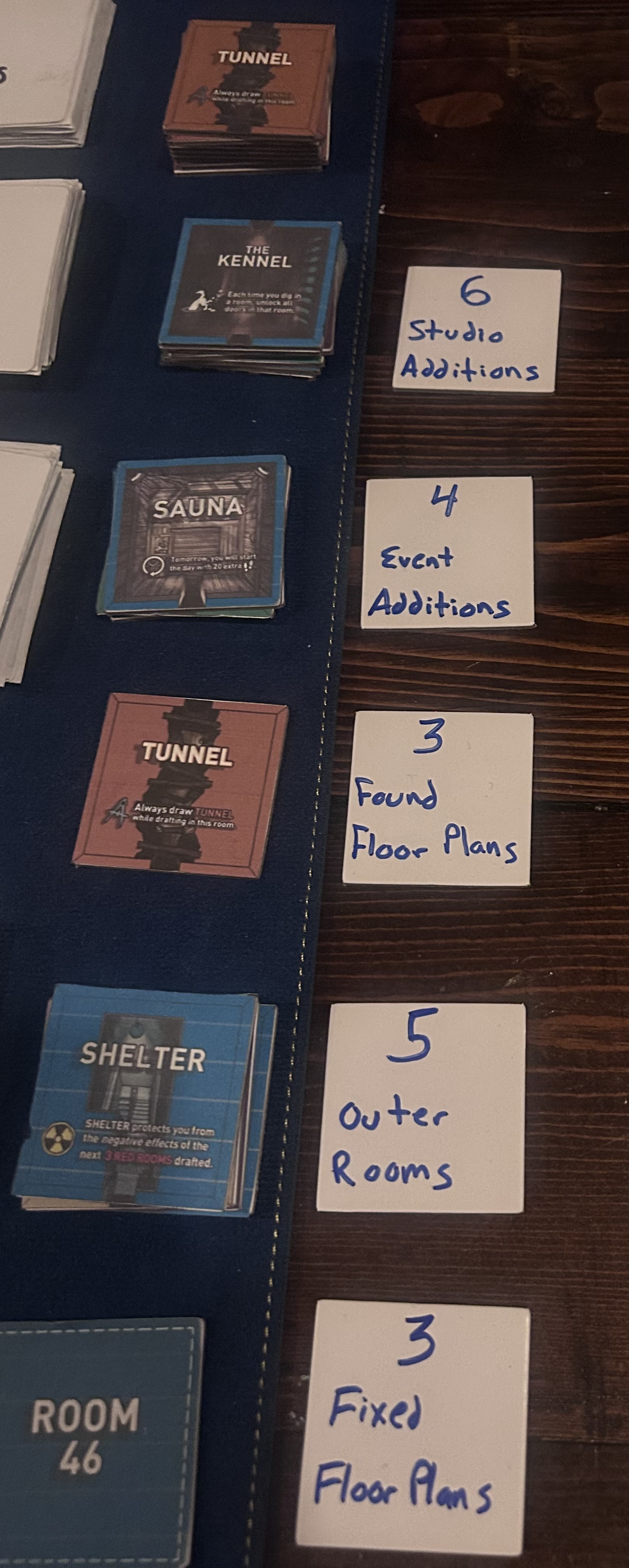 Stacks of Studio Additions, Event Additions, Found Floor Plans, Outer Rooms and Fixed Floor Plans sitting beside the board — largely untouched after three full runs