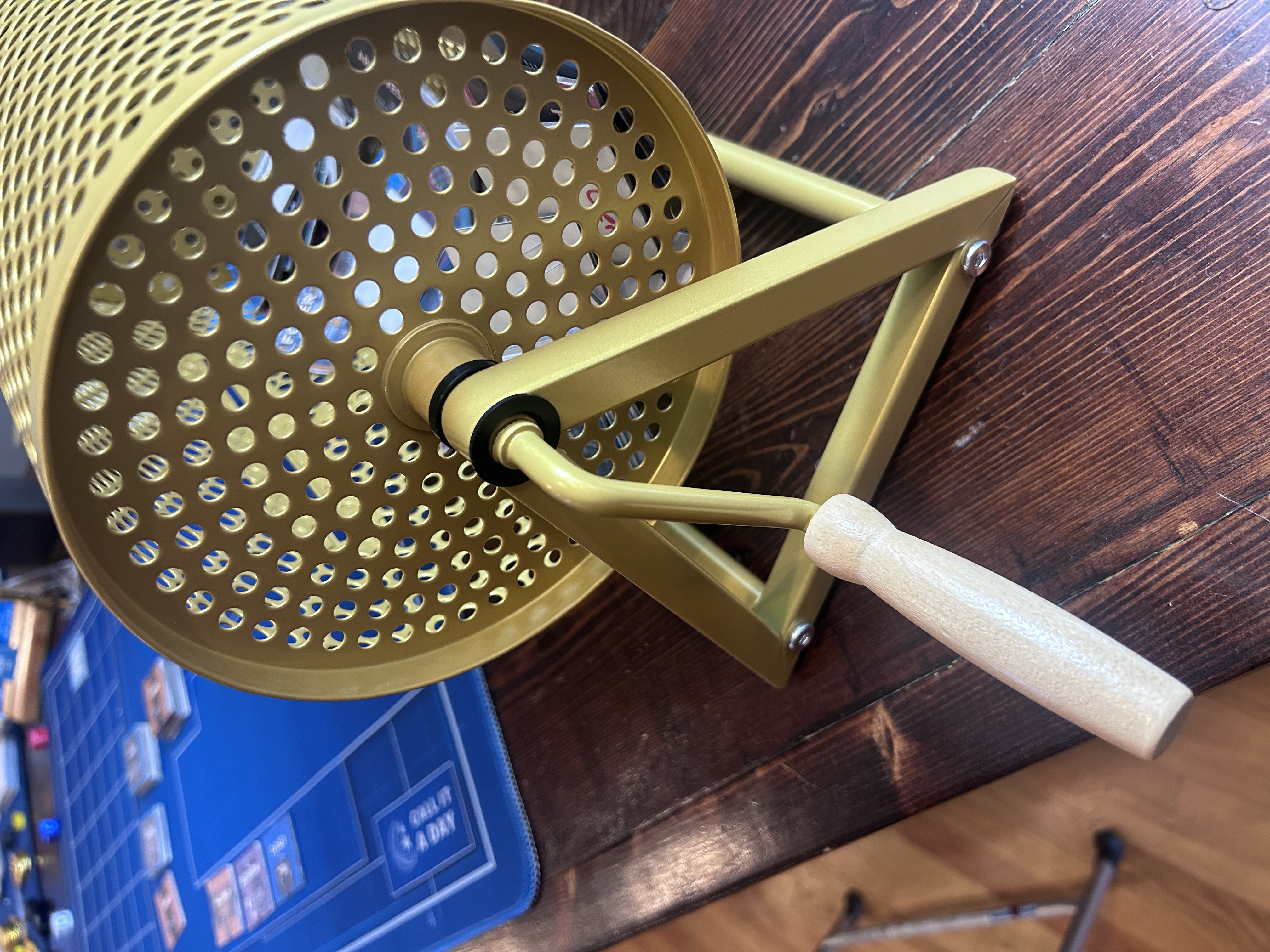 Back of the spinner showing the wooden crank handle and triangular brass stand