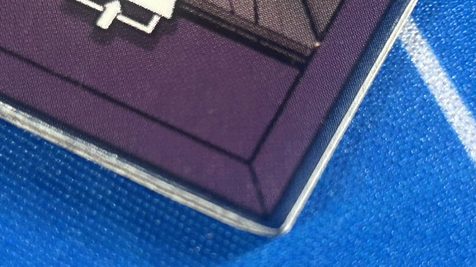 Macro of a purple bedroom tile edge: the white door notch, the purple frame, and a thin blue rim at the outer edge