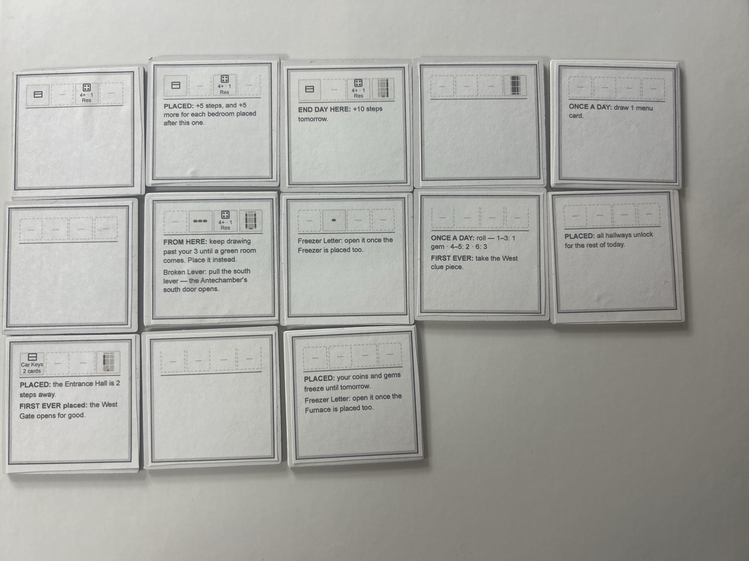 The same thirteen tiles turned over, each back carrying a four-slot strip across the top and prose rule text underneath, several of the slots showing only a dash