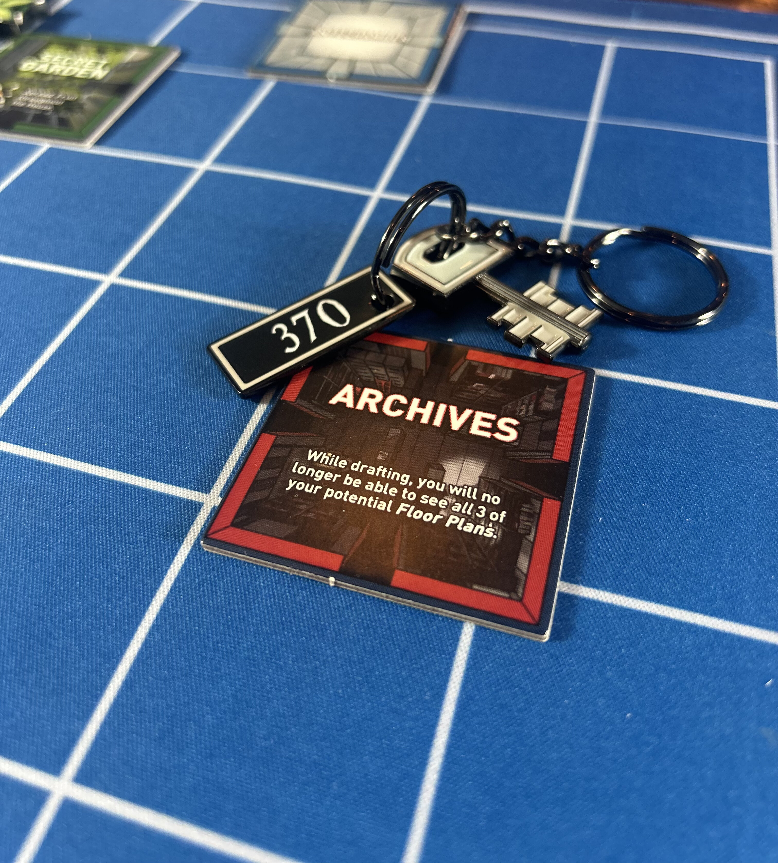 A metal keychain with a numbered tag reading 370, beside the Archives tile